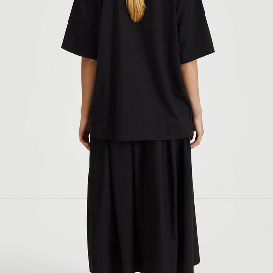 Person wearing a black outfit with a plain background