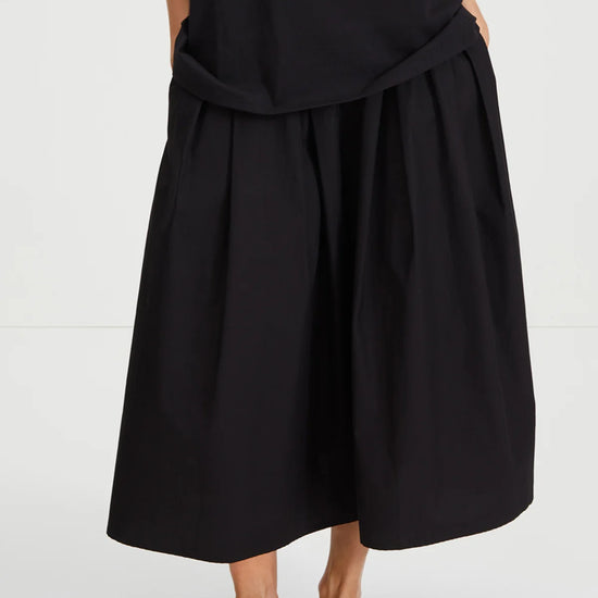 Person wearing a black dress with a white background