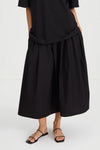 Person wearing a black dress with a white background