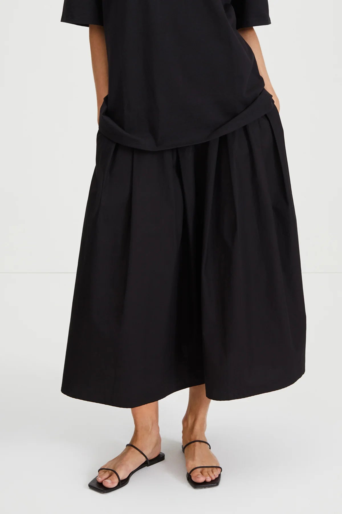 Person wearing a black dress with a white background