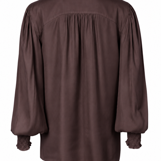 A dark brown long-sleeve blouse shown from the back, featuring a gathered smocked back, a textured ruffled mock neck, and ruffled cuffs, displayed on a clean white background.