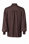 A dark brown long-sleeve blouse shown from the back, featuring a gathered smocked back, a textured ruffled mock neck, and ruffled cuffs, displayed on a clean white background.