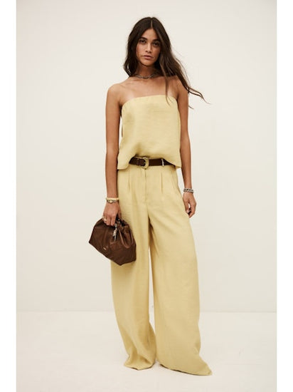 Model wearing pale yellow bandeau top with matching trousers from ba&sh