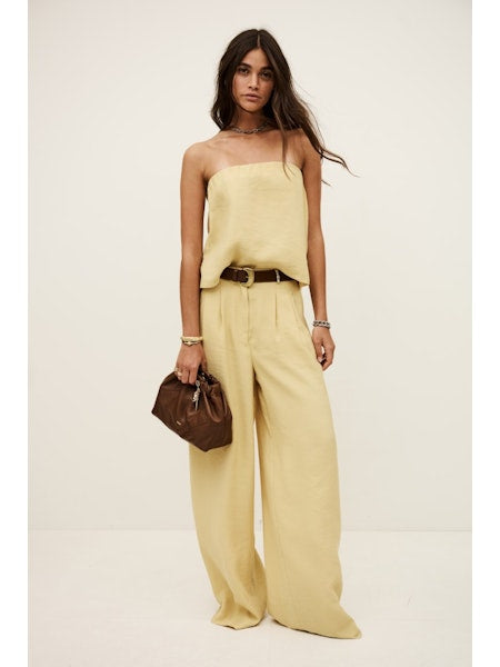 Model wearing pale yellow bandeau top with matching trousers from ba&sh