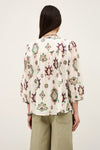 Person wearing a patterned blouse with a plain background rear view from ba&sh