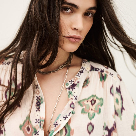 Woman wearing a patterned blouse with a neutral background from ba&sh