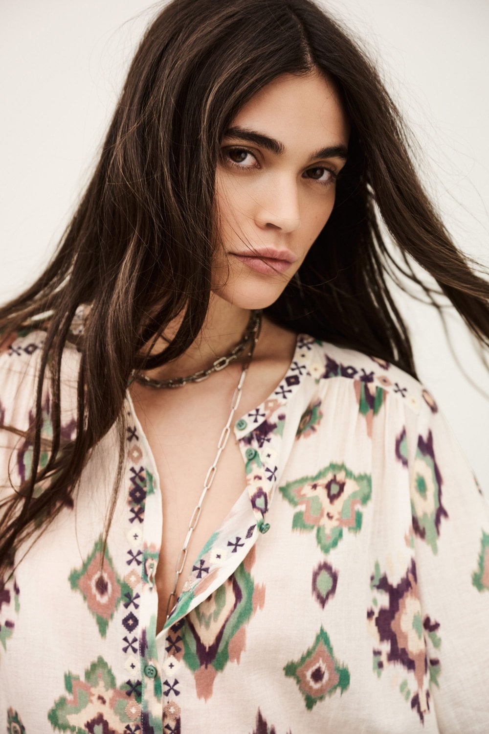 Woman wearing a patterned blouse with a neutral background from ba&sh