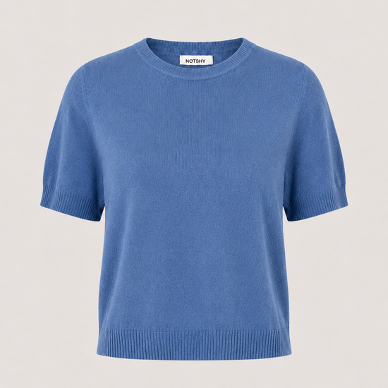 A short-sleeve crewneck knit sweater in a medium blue color, displayed on a neutral light beige background.