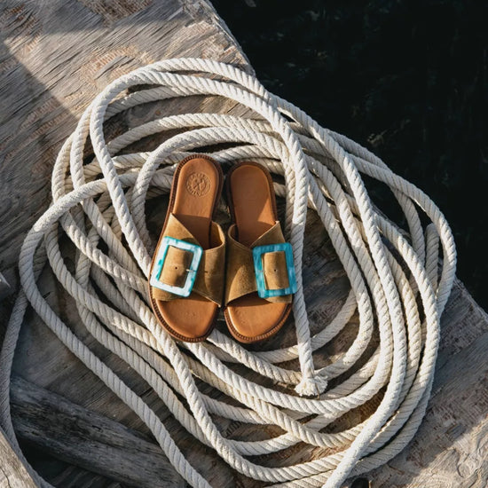 Brown sandals with turquoise buckles on a coiled rope