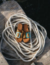 Brown sandals with turquoise buckles on a coiled rope