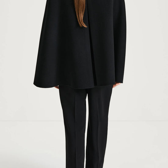Person wearing a black suit on a white background