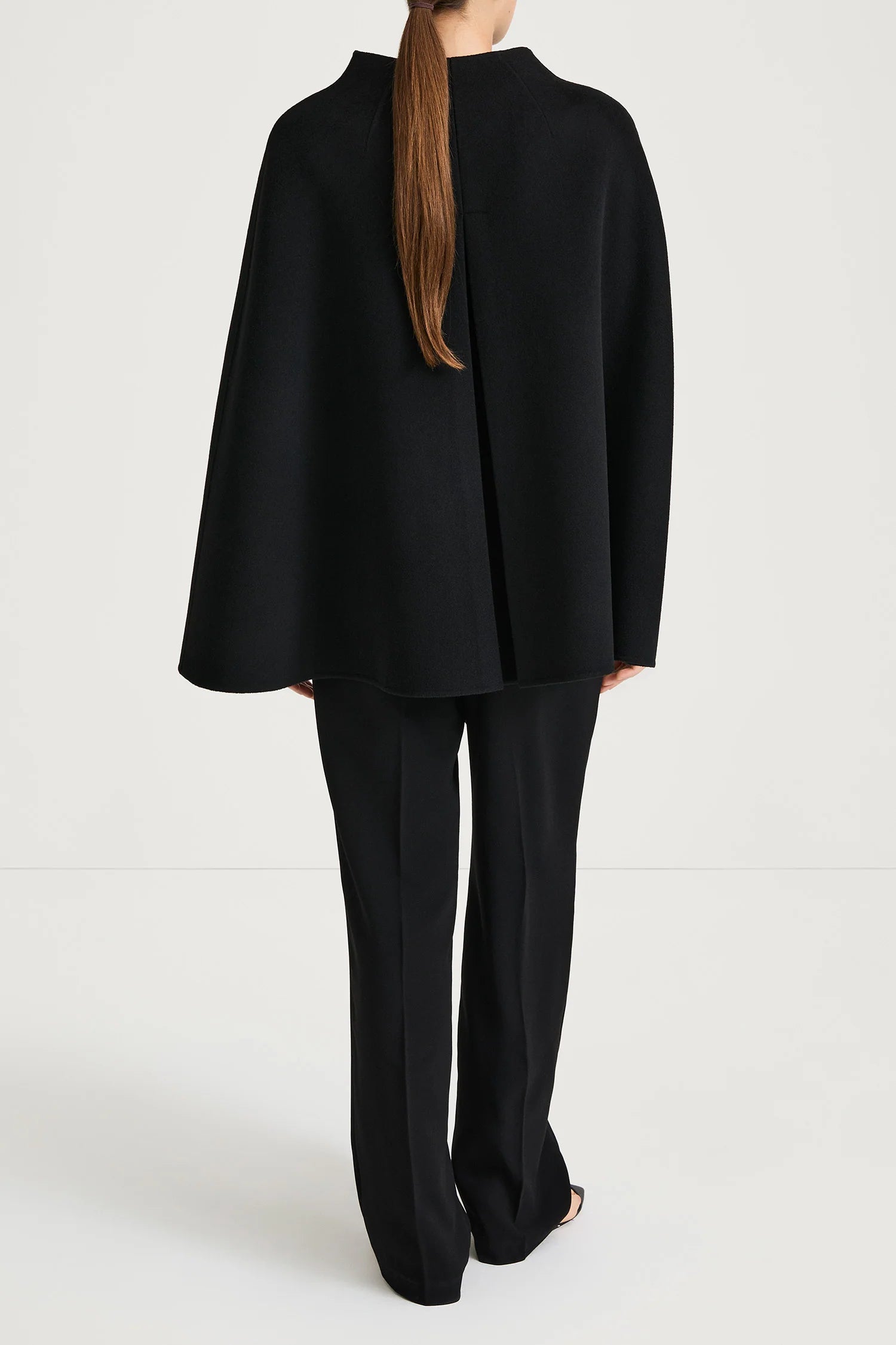 Person wearing a black suit on a white background