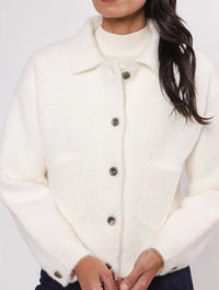 white boxy soft cardigan with classic collar and 2 front patch pockets  close up