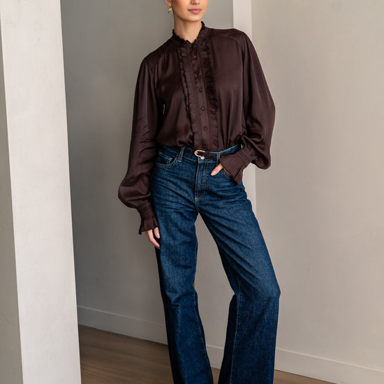 Woman wearing brown shirt and jeans posing