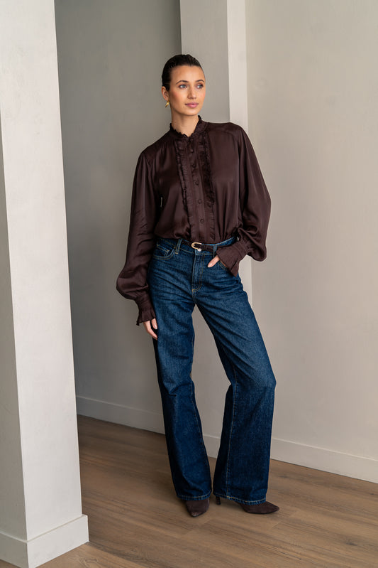 Woman wearing brown shirt and jeans posing