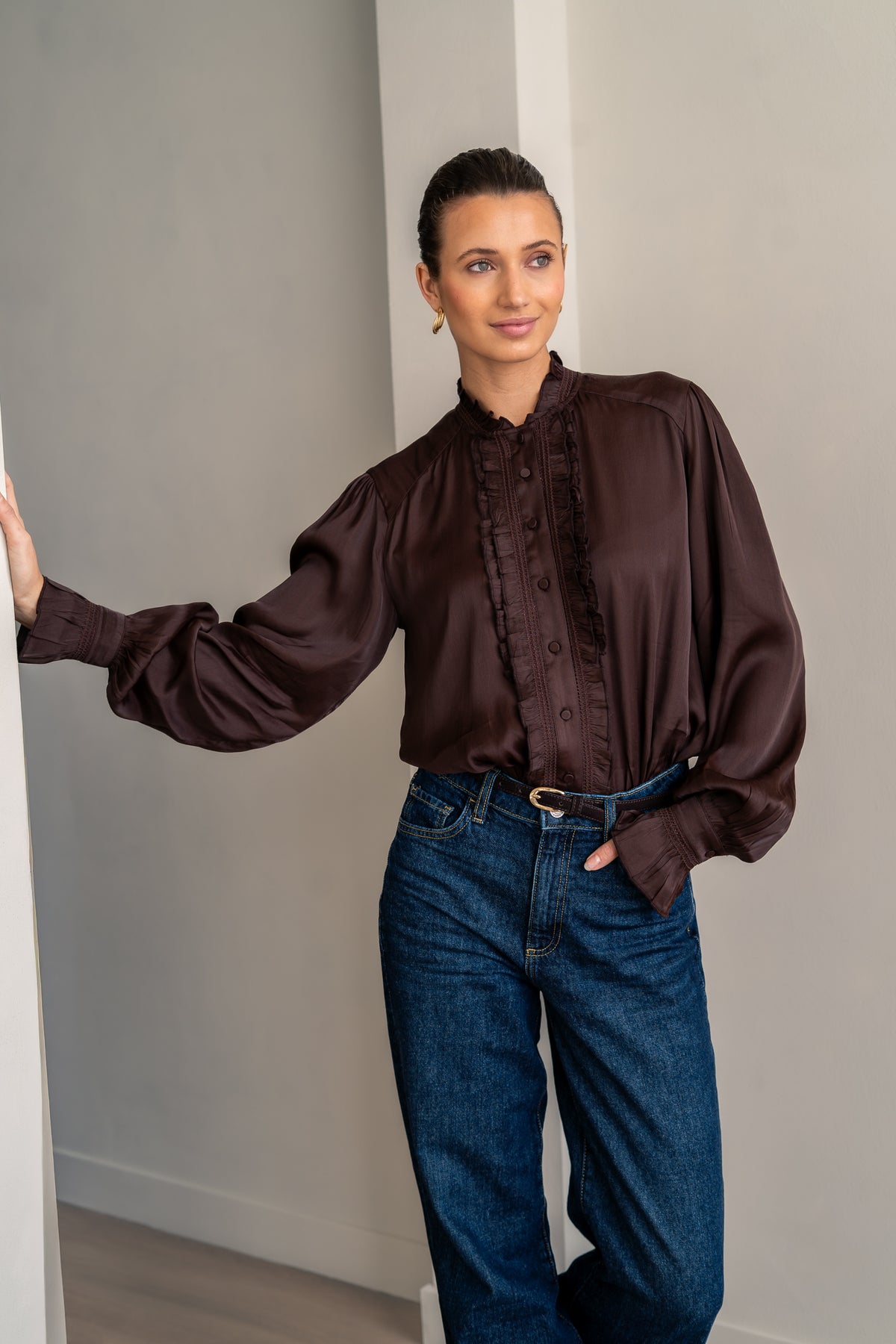 Woman wearing brown shirt and jeans posing close up