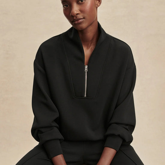 Quarter zip and slightly cropped black sweat top with shawl collar and V neckline from varley model shot