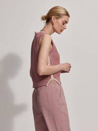 Model wearing dusky pink round neck vest top, side view.