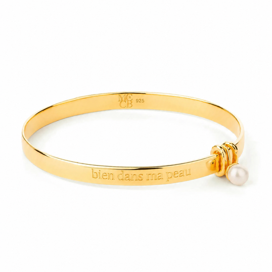 Gold Bangle with engraving on plain background