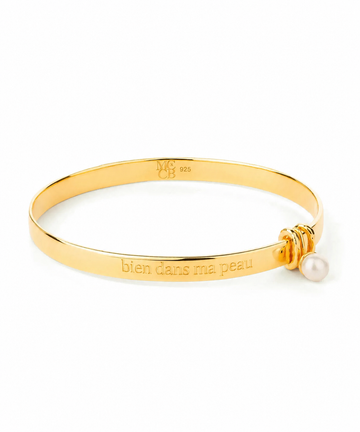 Gold Bangle with engraving on plain background