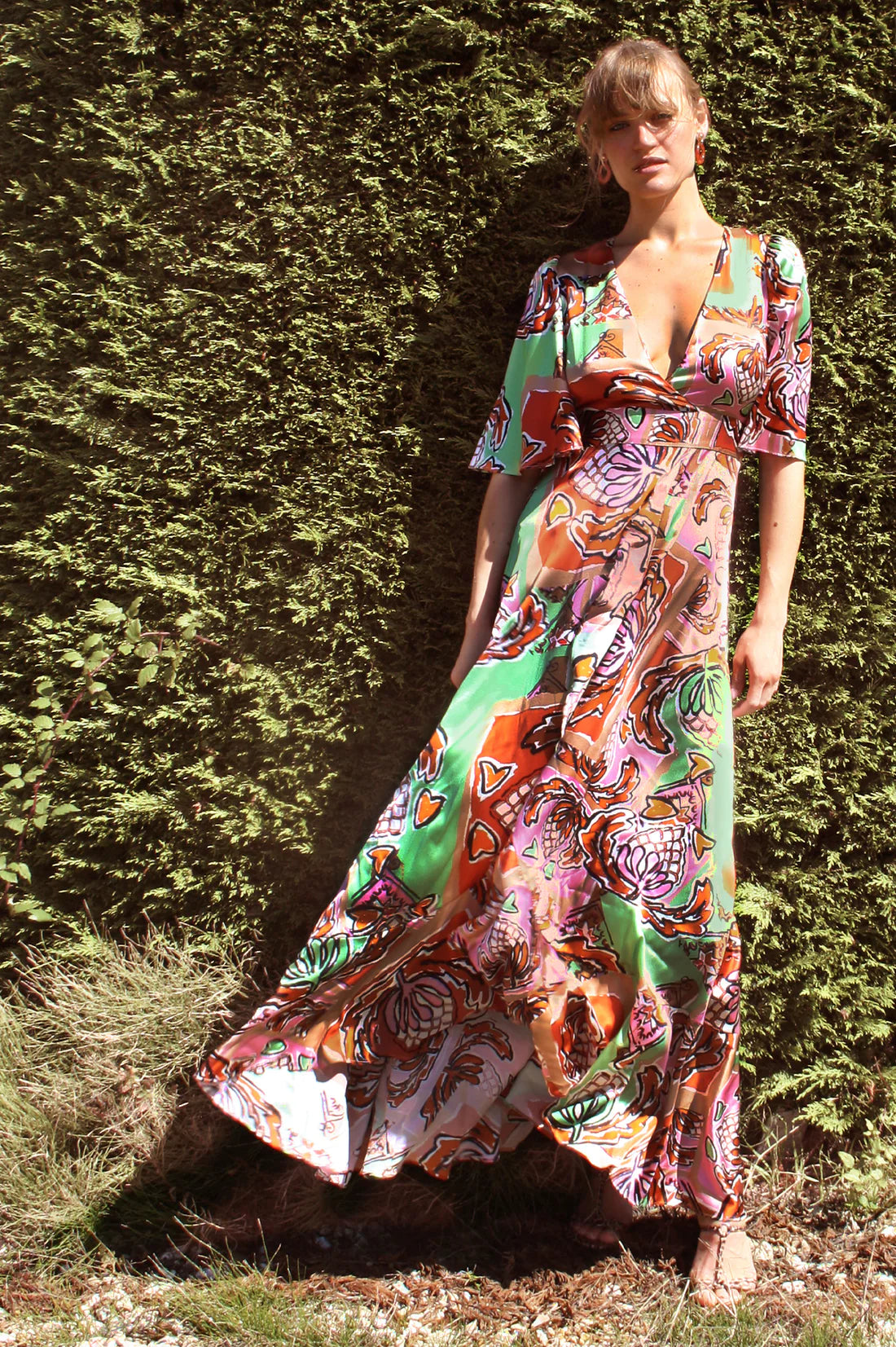 Green brown pink and black silk faux wrap dress with elbow length sleeves and a cascading shaped maxi hemline