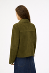 Person wearing a green jacket and blue jeans on a white background
