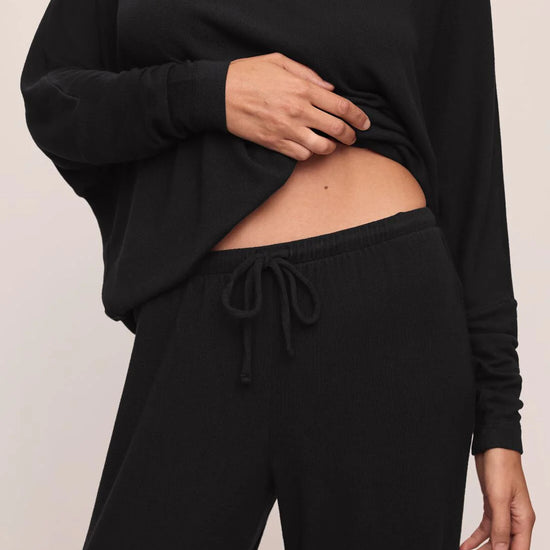 close up of black drawstring trouser on a white background
