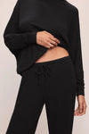 close up of black drawstring trouser on a white background