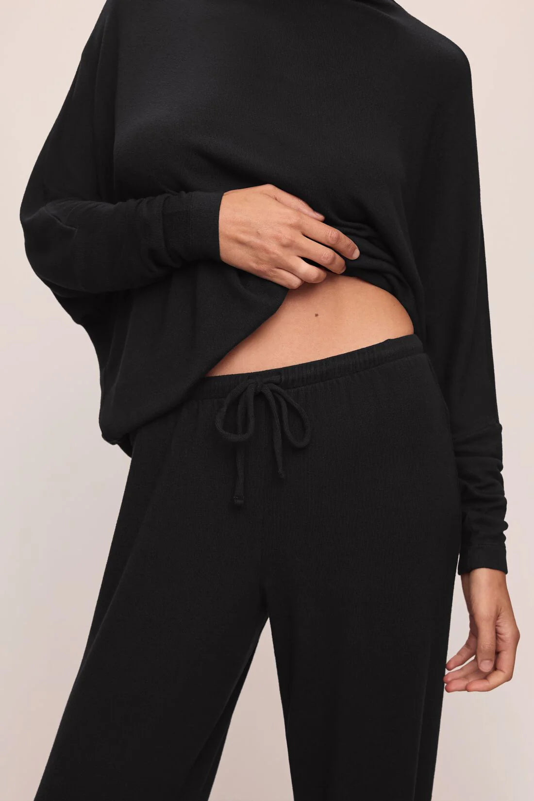 close up of black drawstring trouser on a white background