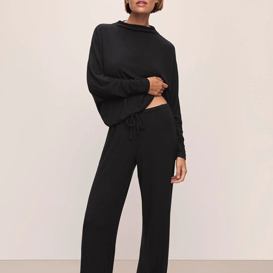 model wearing black outfit on plain background