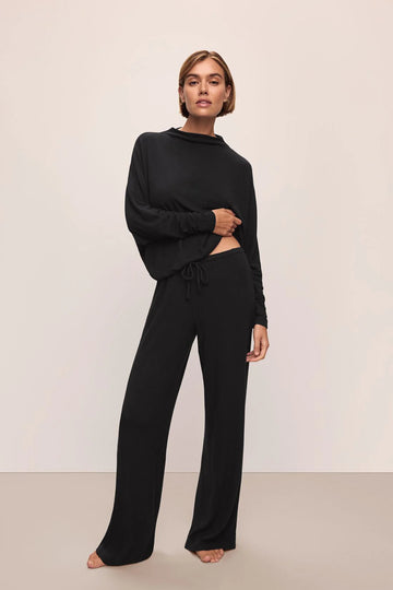 model wearing black outfit on plain background