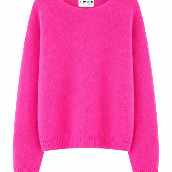 A bright pink crewneck sweater with long sleeves and ribbed cuffs and hem, shown against a plain white background. The inside collar label shows the brand name 'TWNS'.
