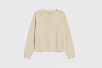 A light beige knit crewneck sweater with long sleeves, laid flat against a light gray background.