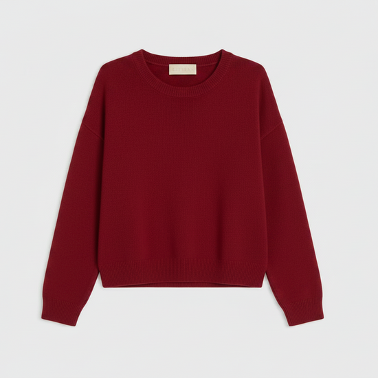 A light red crewneck sweater with long sleeves, laid flat against a clean white background.