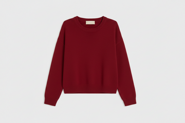 A light red crewneck sweater with long sleeves, laid flat against a clean white background.