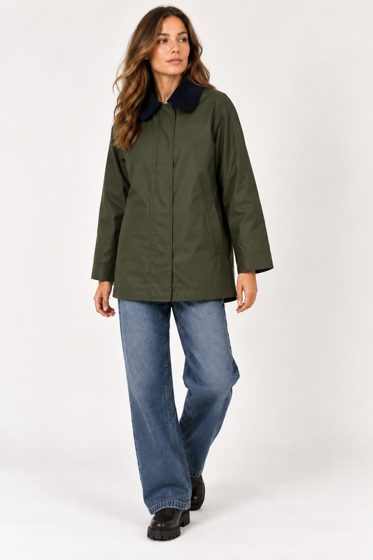 model showing a green rain coat with a navy collar. also wearing blue jeans and black boots against a plain white background