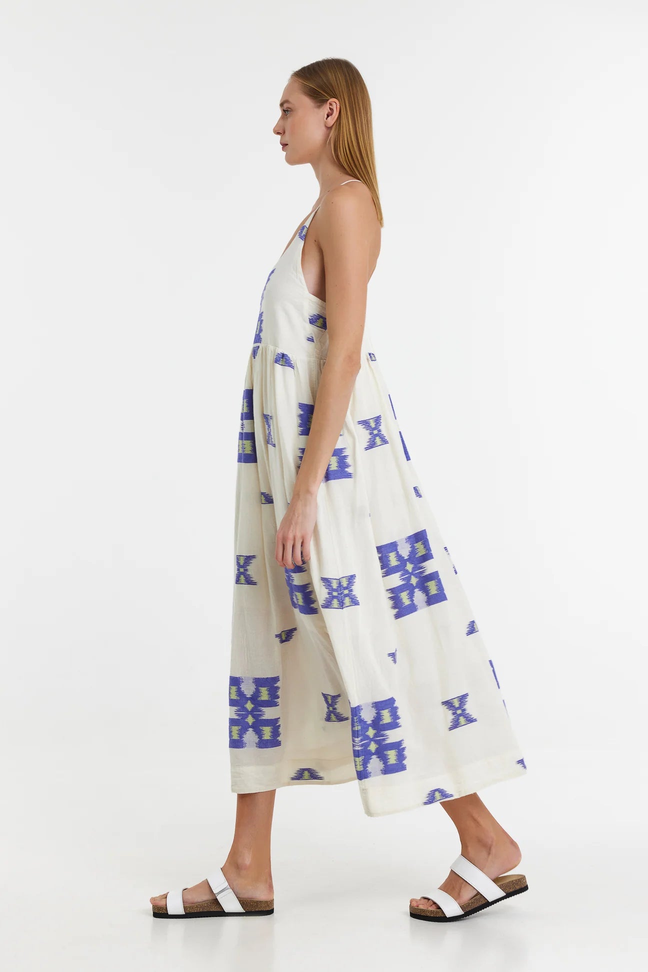 Ecru midi dress with empire line and spaghetti straps that cross at the back with blue and lime abstract woven design throughout