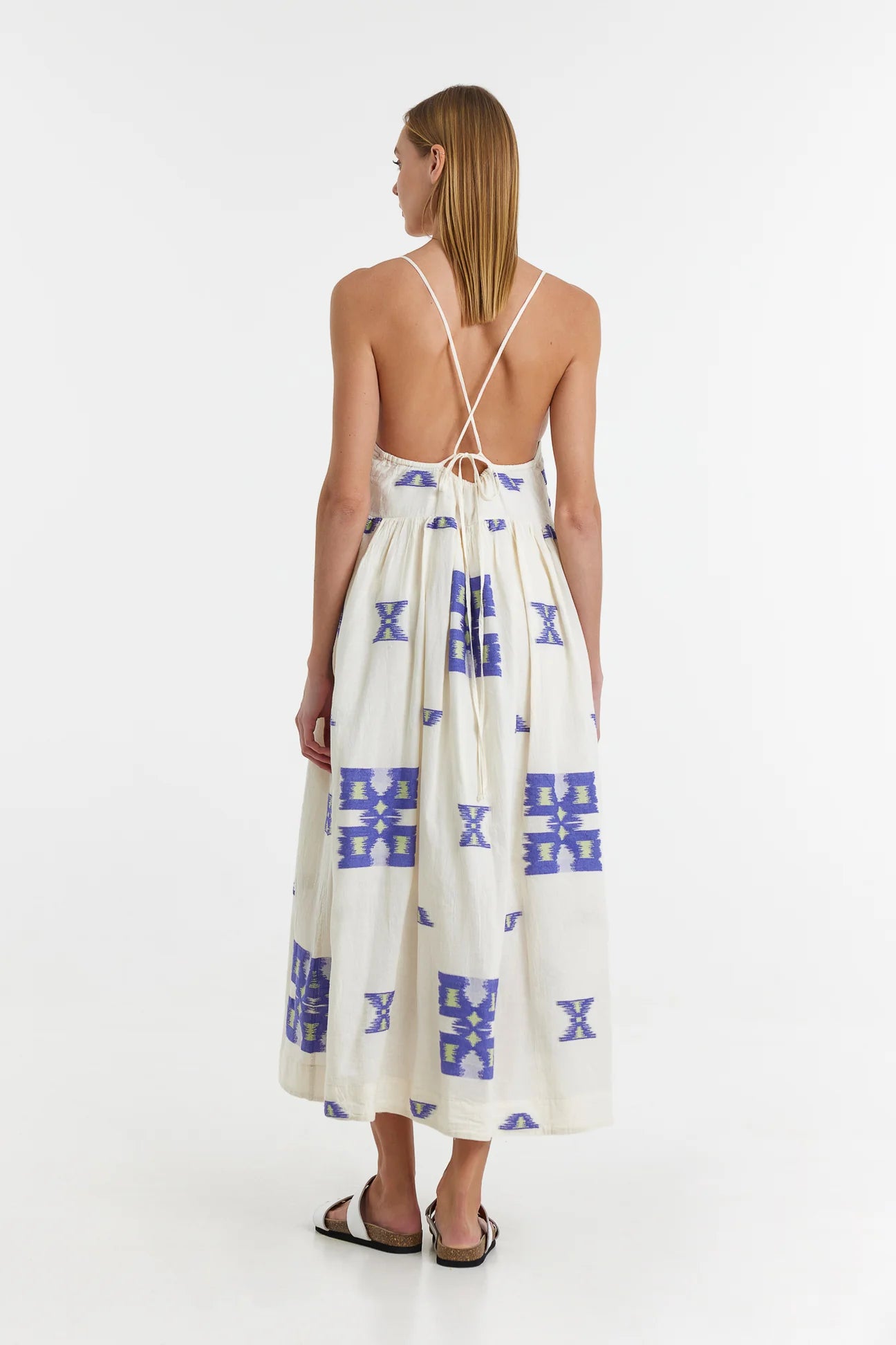 Ecru midi dress with empire line and spaghetti straps that cross at the back with blue and lime abstract woven design throughout