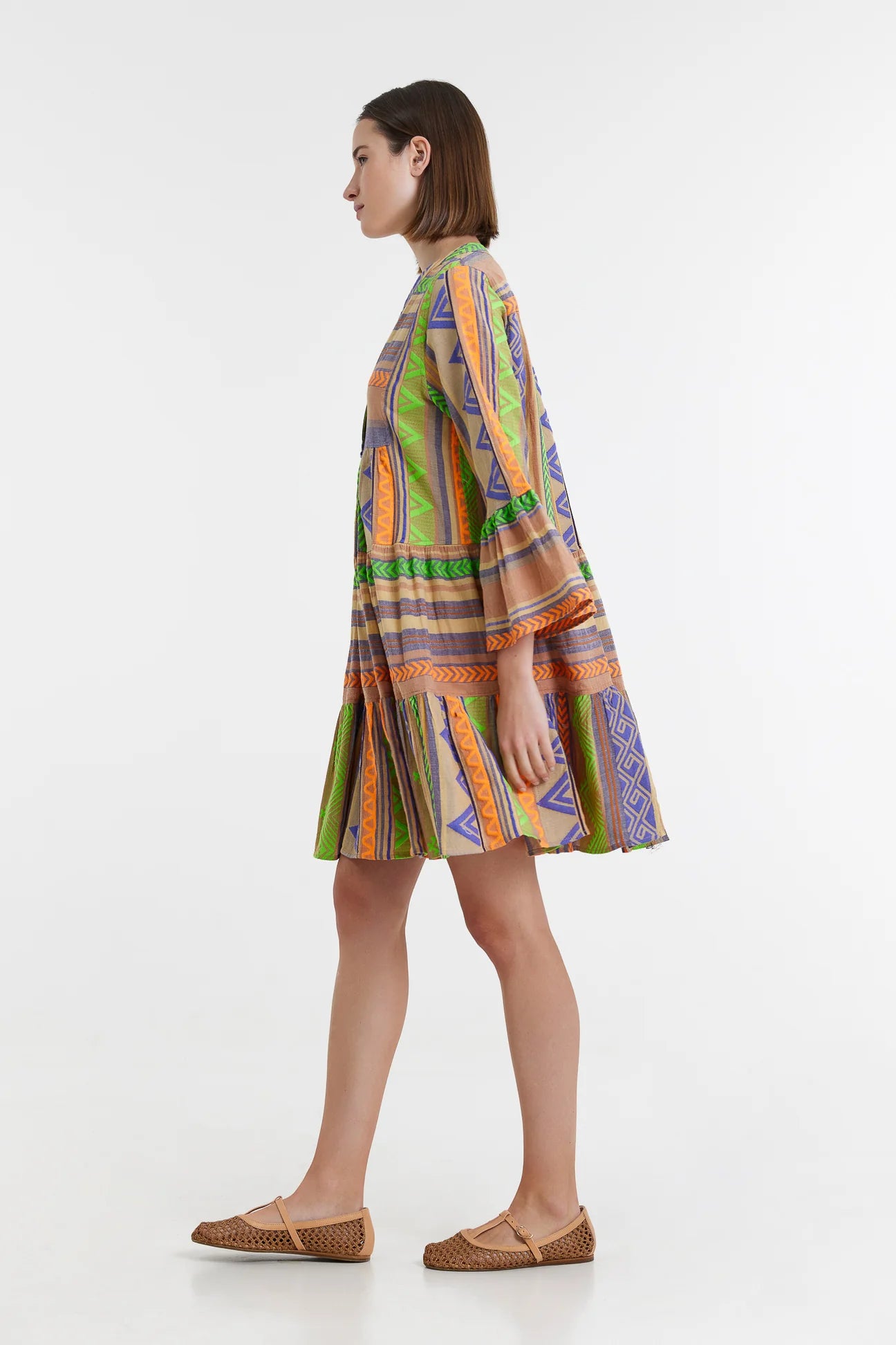 Biege notch neck beach dress with long fluted sleeves and tiered skirt with neon green orange and purple embroidery