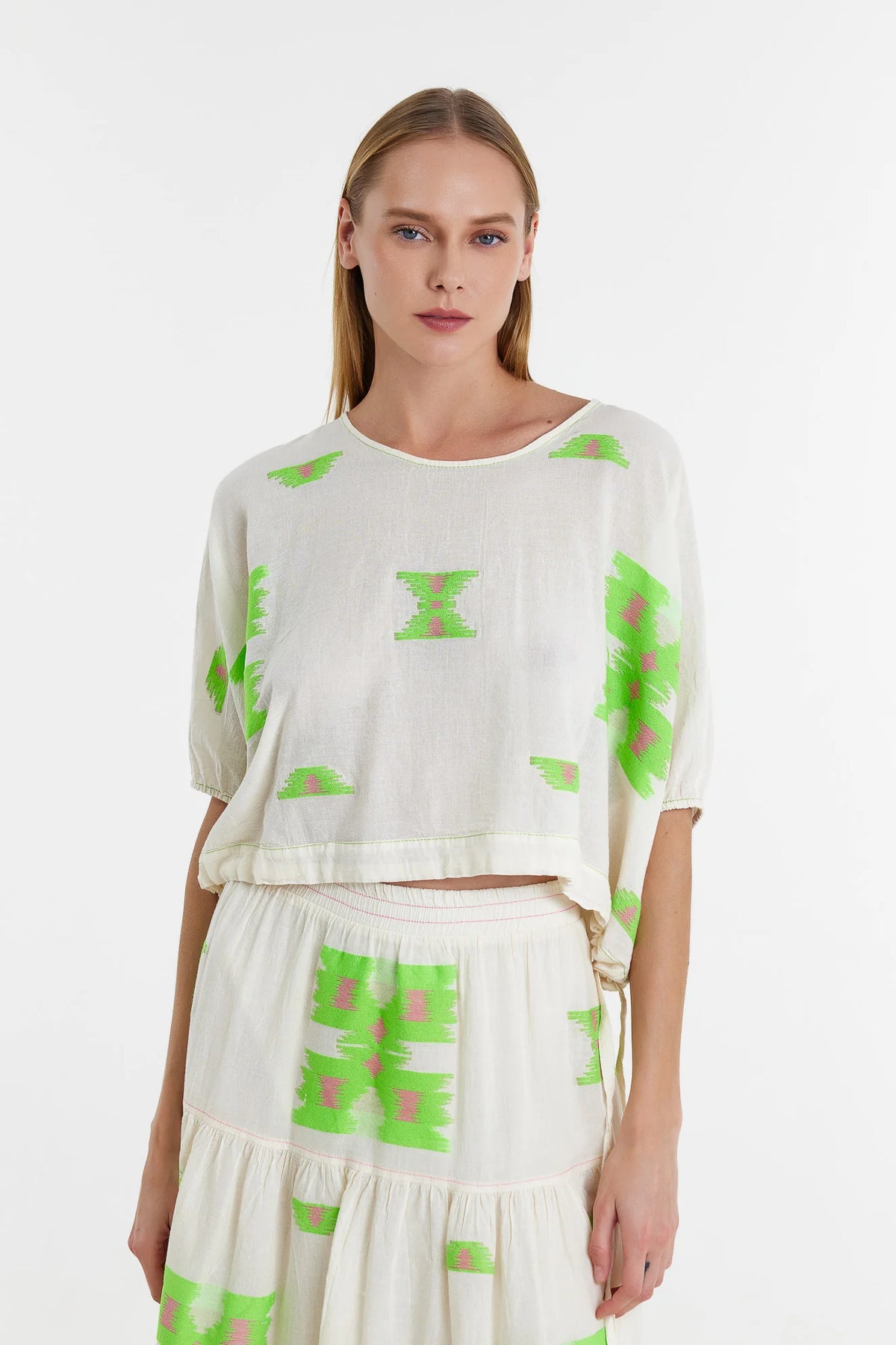 Short top with grown on short sleeves with elasticated cuffs and drawstring waist with cornflower pink and green woven abstract bold shapes throughout boxy fit