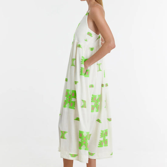 Ecru midi dress with empire line and spaghetti straps that cross at the back with green and pink abstract woven design throughout