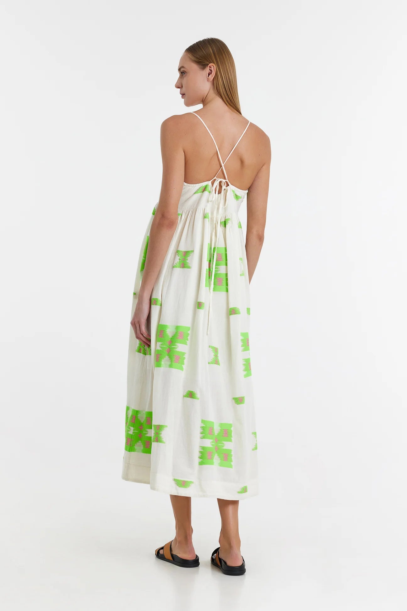 Ecru midi dress with empire line and spaghetti straps that cross at the back with green and pink abstract woven design throughout