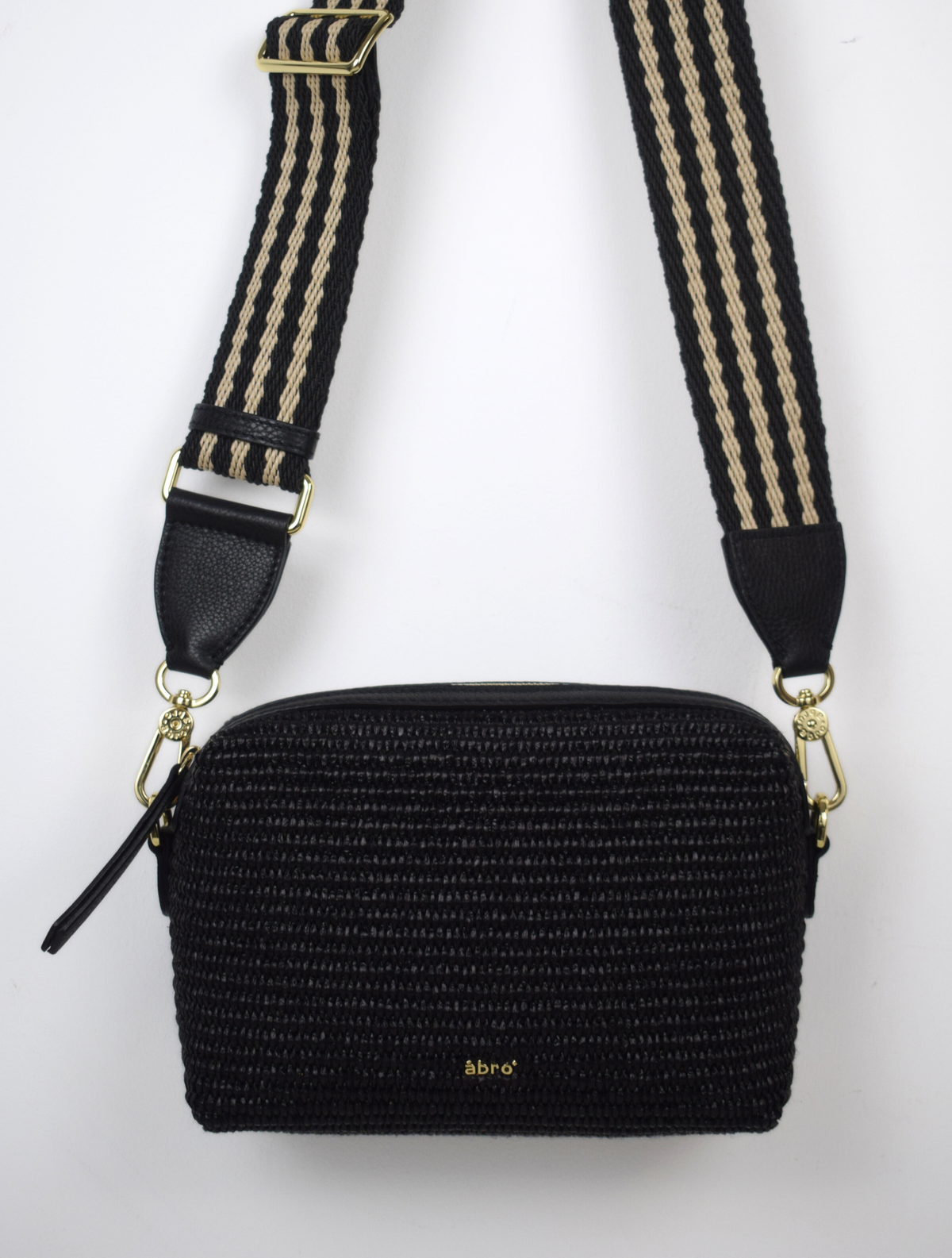 A black raffia bag with a stripe strap.