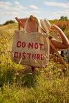 straw bag with slogan hanging on a deck chair 