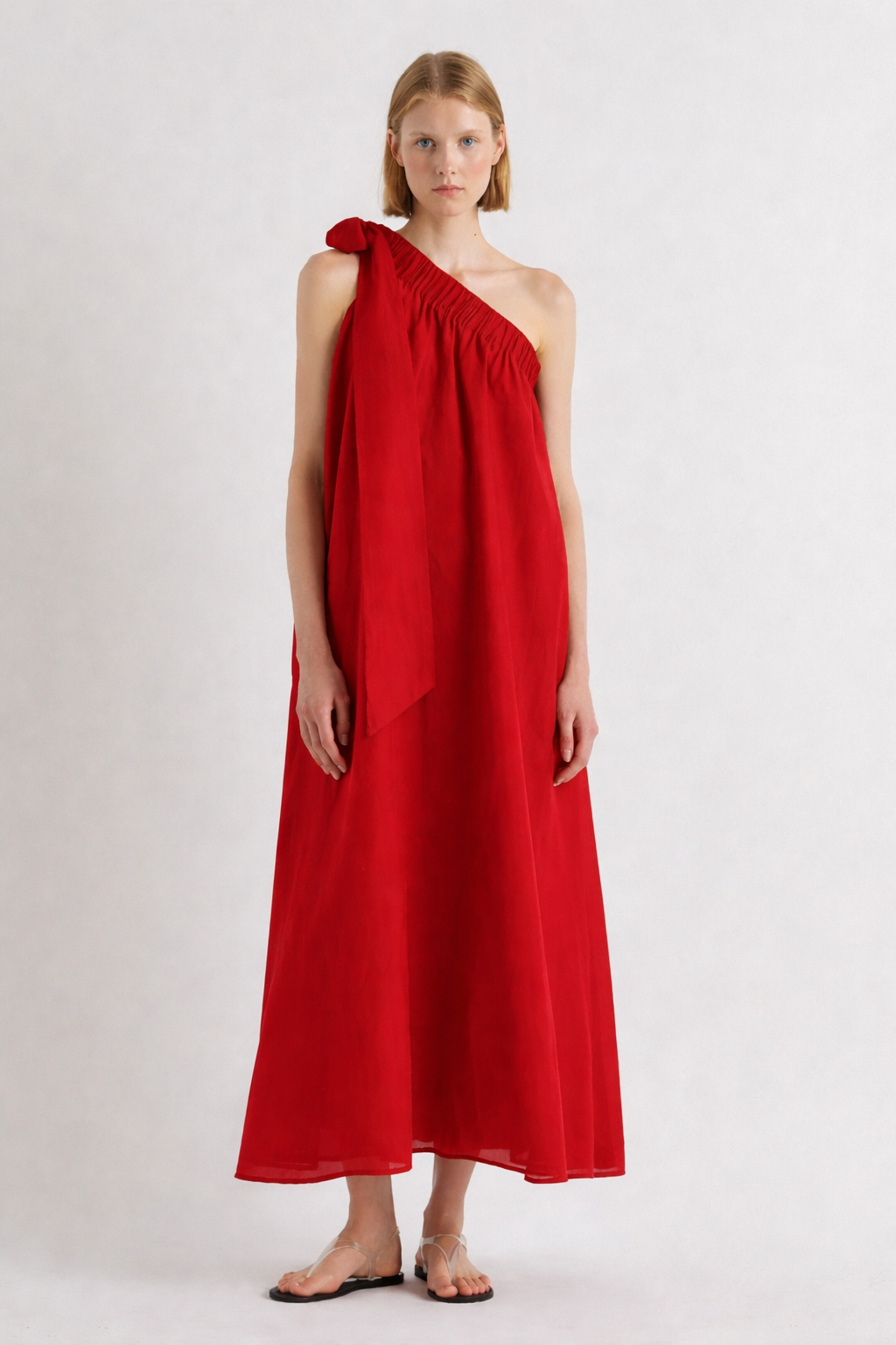 Woman wearing a red one-shoulder dress on a white background