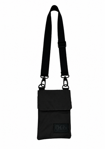 A black nylon crossbody phone bag with a long adjustable shoulder strap and a small black brand patch on the front pocket, shown against a plain white background.