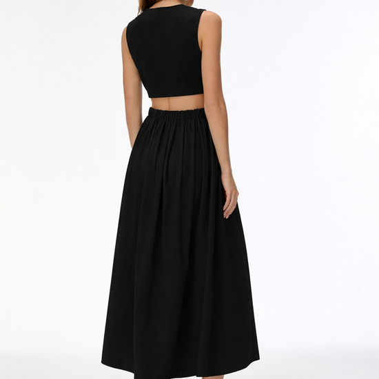 Woman wearing a black sleeveless top and long skirt on a white background