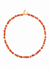A beaded necklace made of round orange-red marbled beads with small gold spacer beads and a gold clasp, shown on a plain white background.