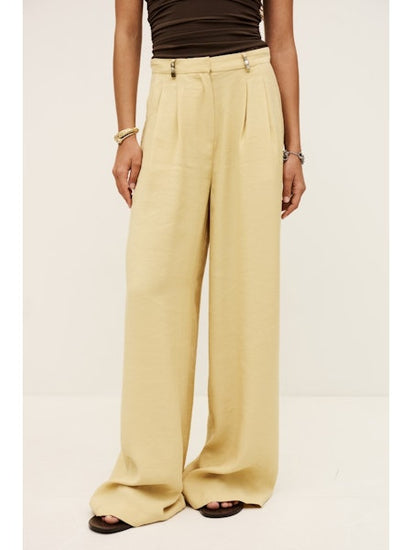 Pale yellow wide-leg pants worn by a person on a white background