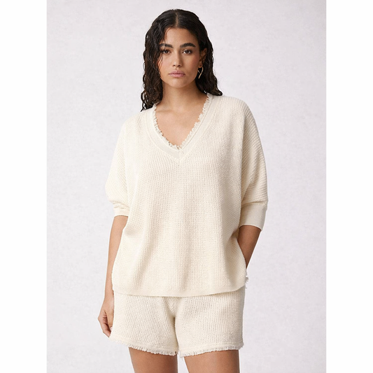 Woman wearing a cream-colored outfit on a white background